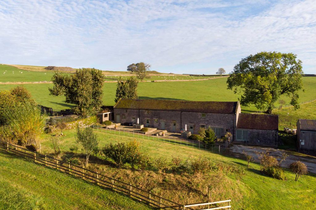 Converted stone barns at Broad Ecton Farm surrounded by White Peak countryside.