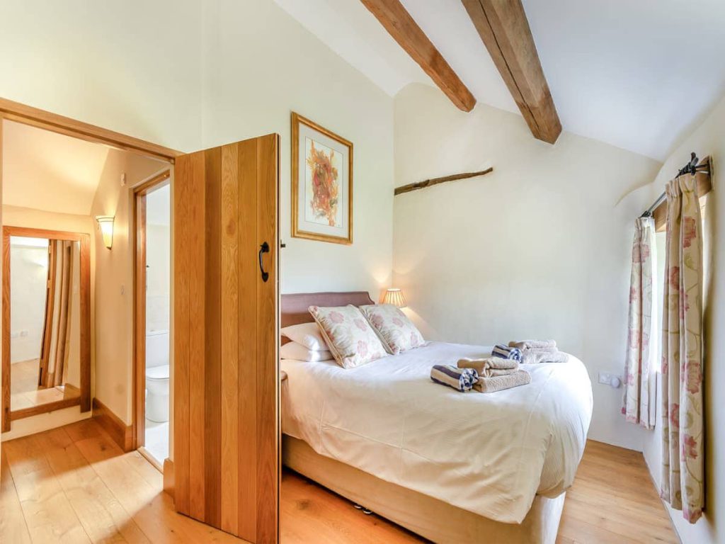 King-size cottage bedroom with exposed wooden beams