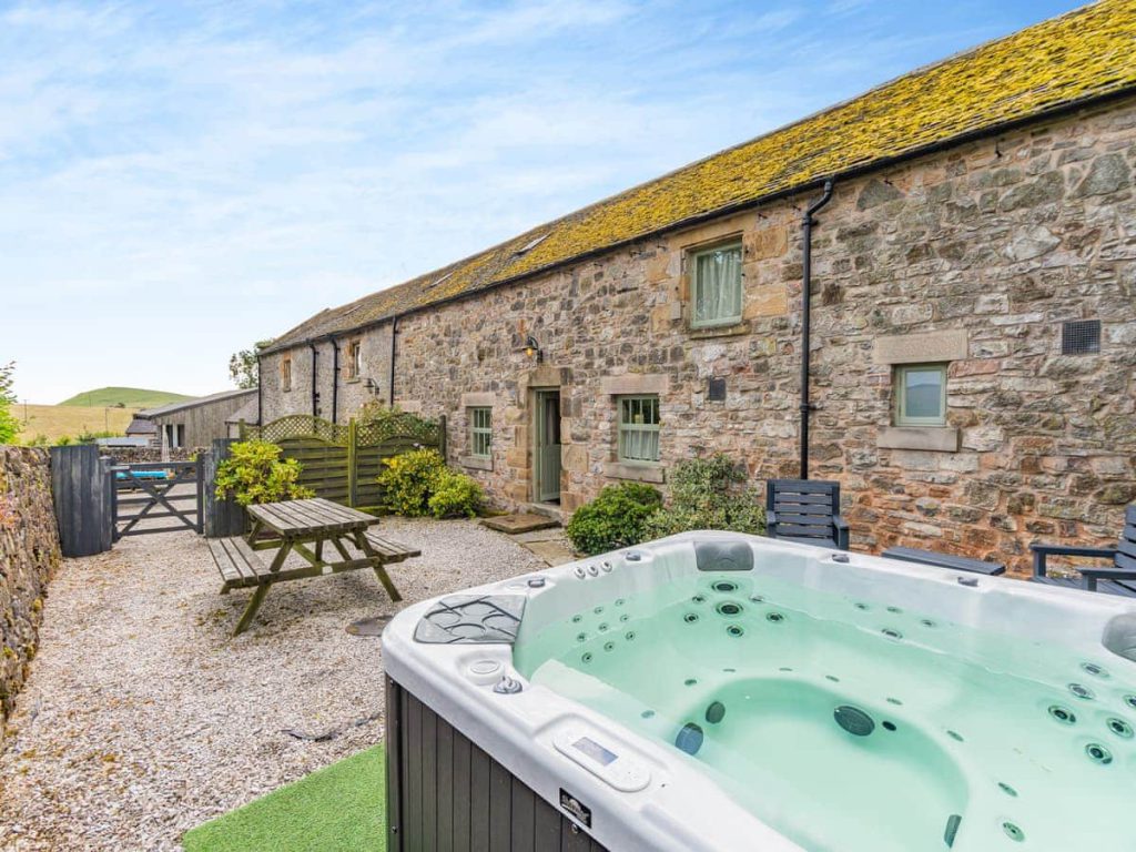 Stone holiday cottage courtyard with a private hot tub