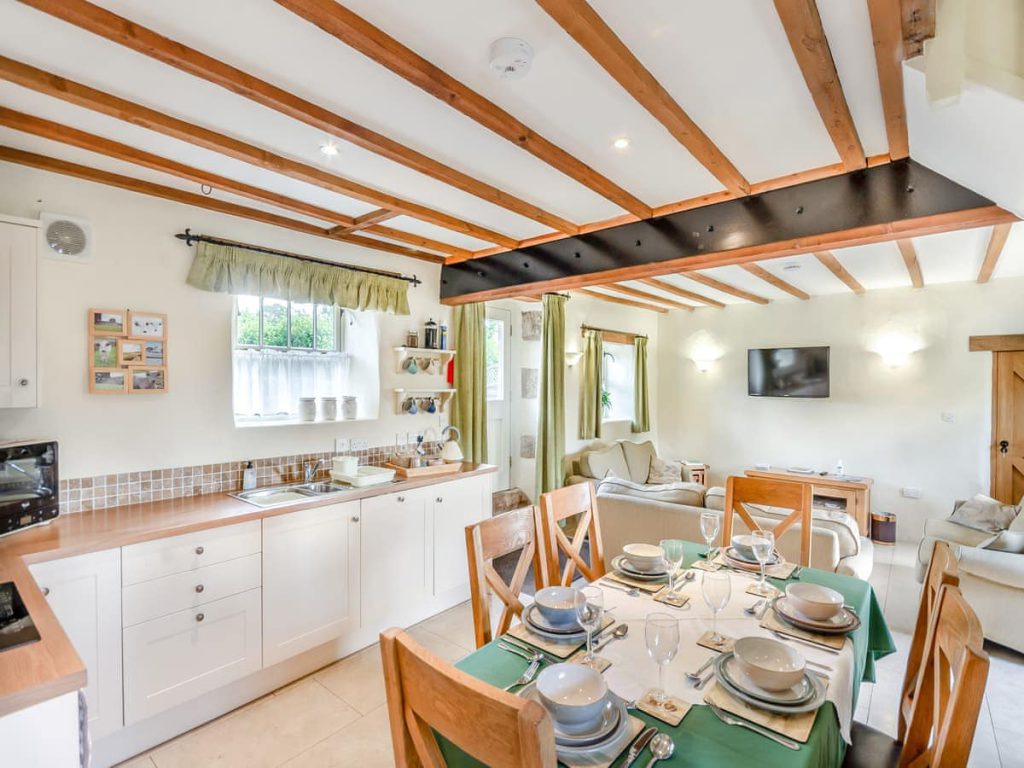Bright open-plan kitchen and dining room with exposed wooden beams